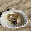 Bague en acier inoxydable dorée avec perle de Tahiti dans un coquillage