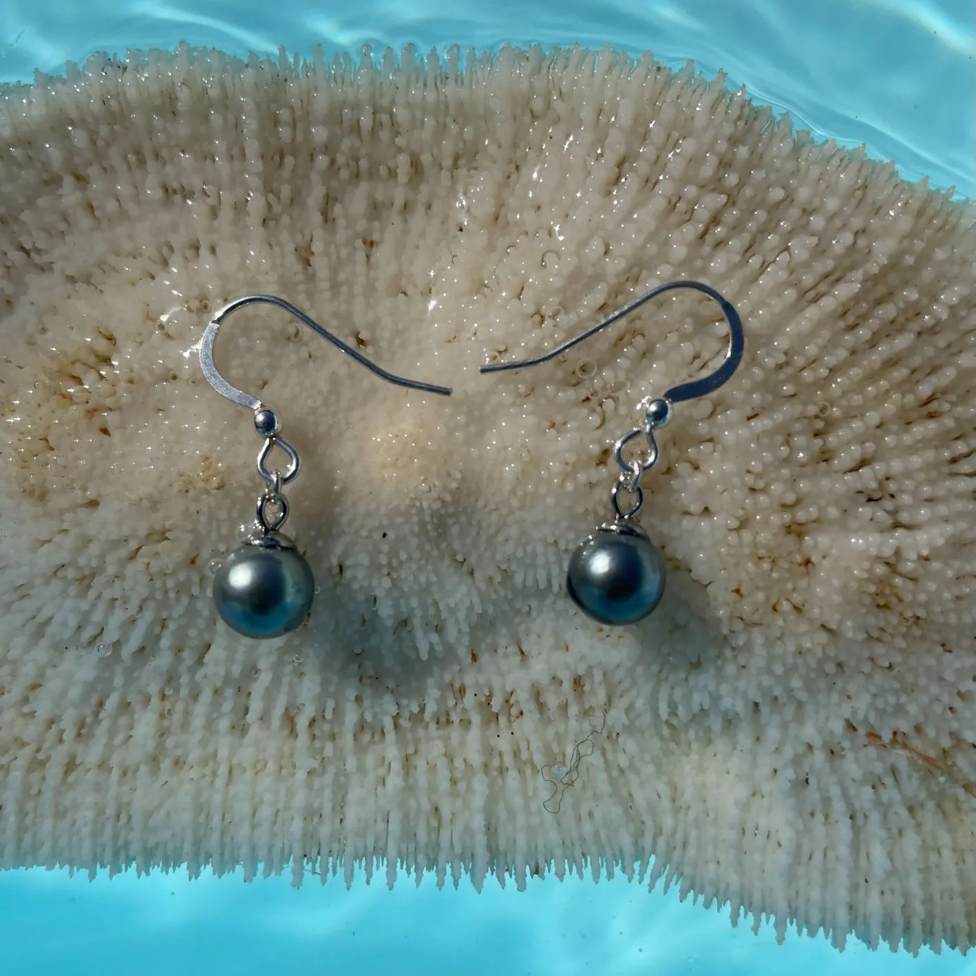 Boucles d’oreilles Maimiti sur un corail dans l'eau