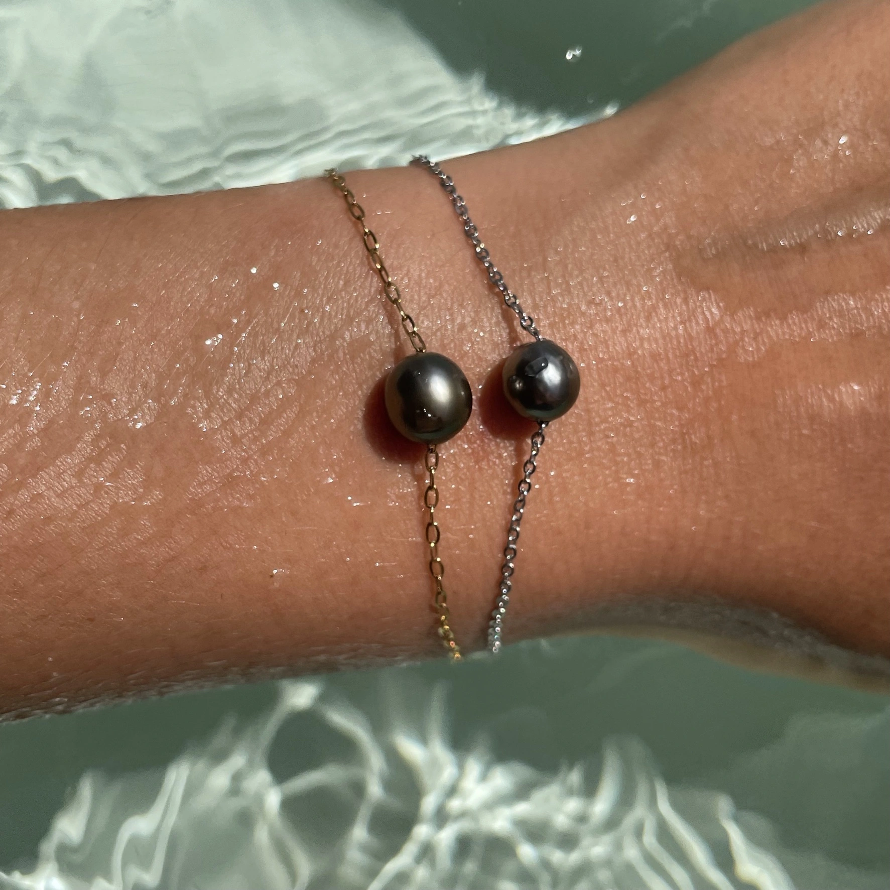 Deux bracelets doré et argenté sur l'eau
